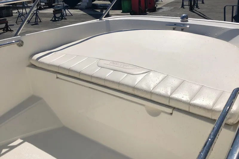 Slide: The Image of 2013 Boston Whaler 150 Super Sport boat interior with cushioned seating. - 23