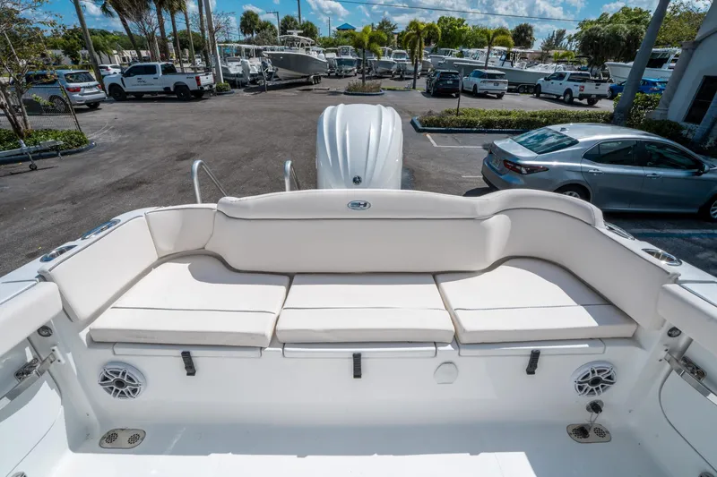 Slide: The Image of 2025 Sea Hunt Ultra 255 SE boat with spacious white seating in a marina setting. - 10