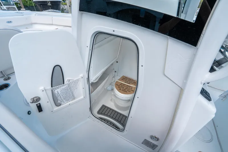 Slide: The Image of 2025 Sea Hunt Ultra 255 SE boat interior with compact marine toilet. - 24