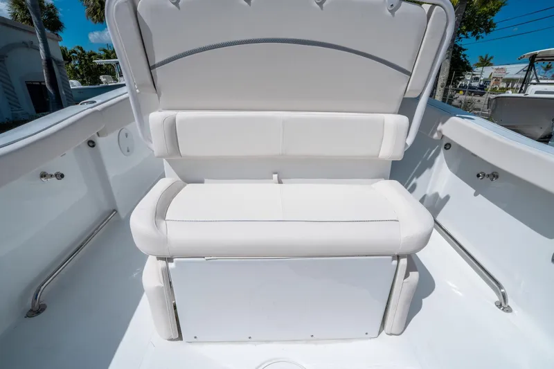 Slide: The Image of 2025 Sea Hunt Ultra 255 SE boat seating, white cushioned bench in bright sunlight. - 15