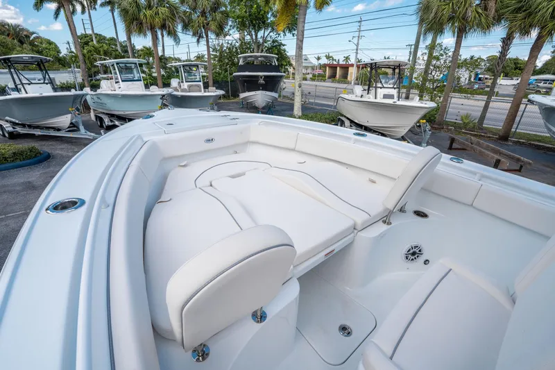 Slide: The Image of 2025 Sea Hunt Ultra 255 SE boat interior with white seating and palm trees in the background. - 25