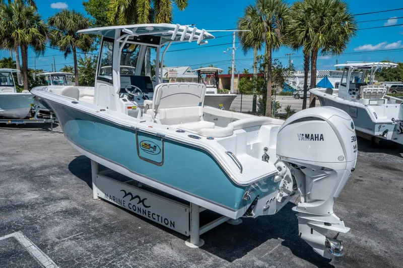 Slide: The Image of 2025 Sea Hunt Ultra 255 SE boat with Yamaha engine, displayed outdoors under clear blue sky. - 4