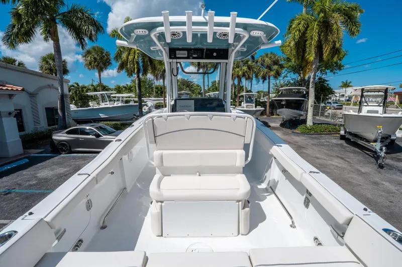 Slide: The Image of 2025 Sea Hunt Ultra 255 SE boat with seating, parked under palm trees. - 9