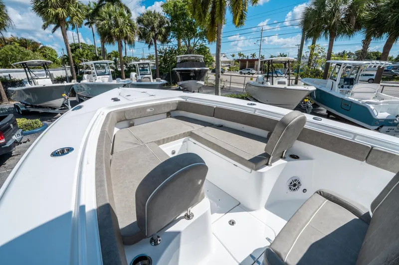 Slide: The Image of 2025 Sea Hunt Gamefish 27 FS boat interior with seating, parked among palm trees. - 30