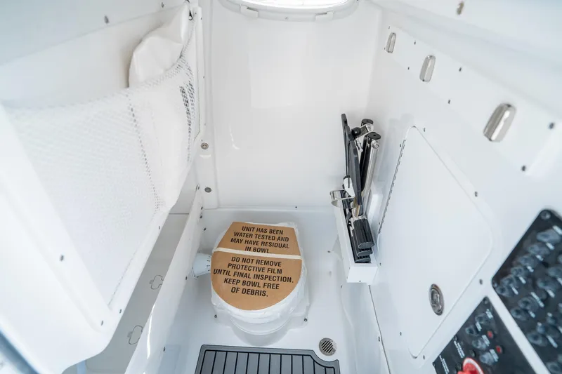 Slide: The Image of Interior of 2025 Sea Hunt Gamefish 27 FS boat, featuring a compact marine toilet. - 29