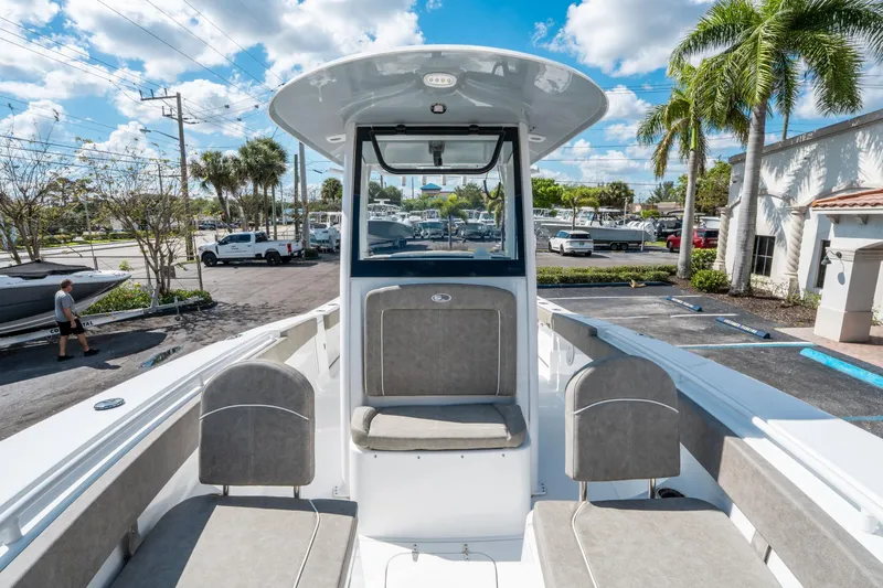 Slide: The Image of 2025 Sea Hunt Gamefish 27 FS boat interior with seating, parked outdoors under a blue sky. - 32