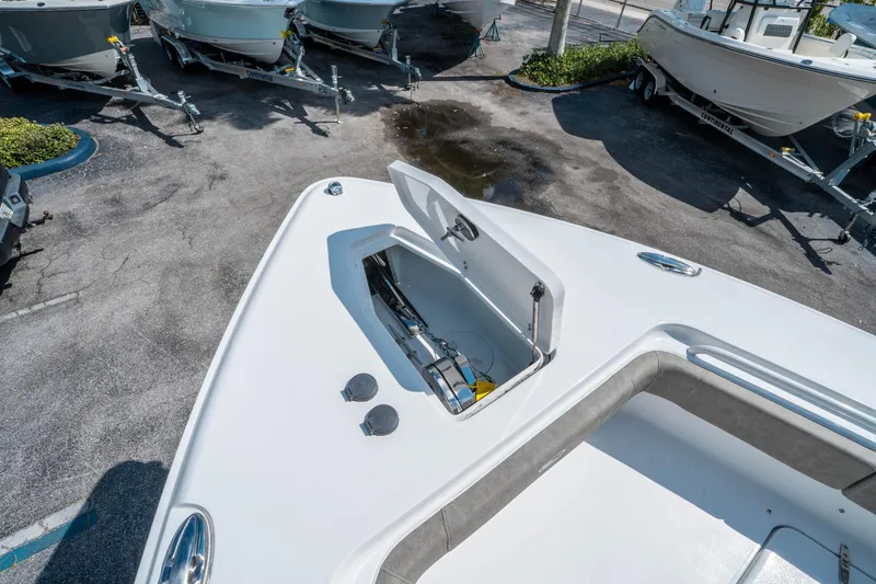 Slide: The Image of 2025 Sea Hunt Gamefish 27 FS boat with open storage compartment, parked among other boats. - 38