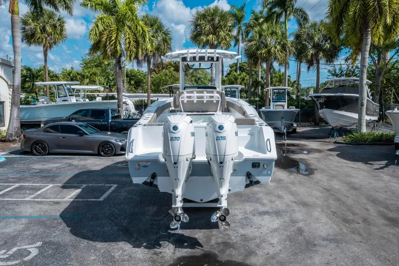 Slide: The Image of 2025 Sea Hunt Gamefish 27 FS boat with dual engines in a sunny marina setting. - 3