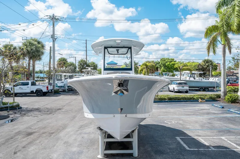 Slide: The Image of 2025 Sea Hunt Gamefish 27 FS boat displayed in a sunny parking lot with palm trees. - 7