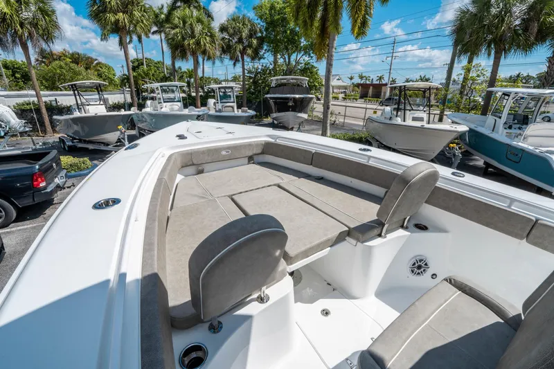 Slide: The Image of 2025 Sea Hunt Gamefish 27 FS boat with spacious seating, parked under palm trees. - 33