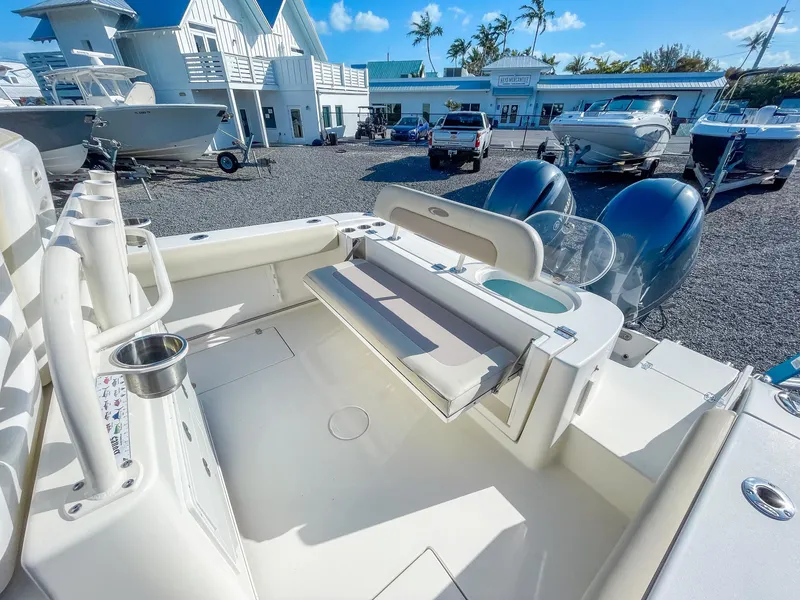 Slide: The Image of 2016 Cobia 277 CC boat interior with seating and dual engines in a marina setting. - 10