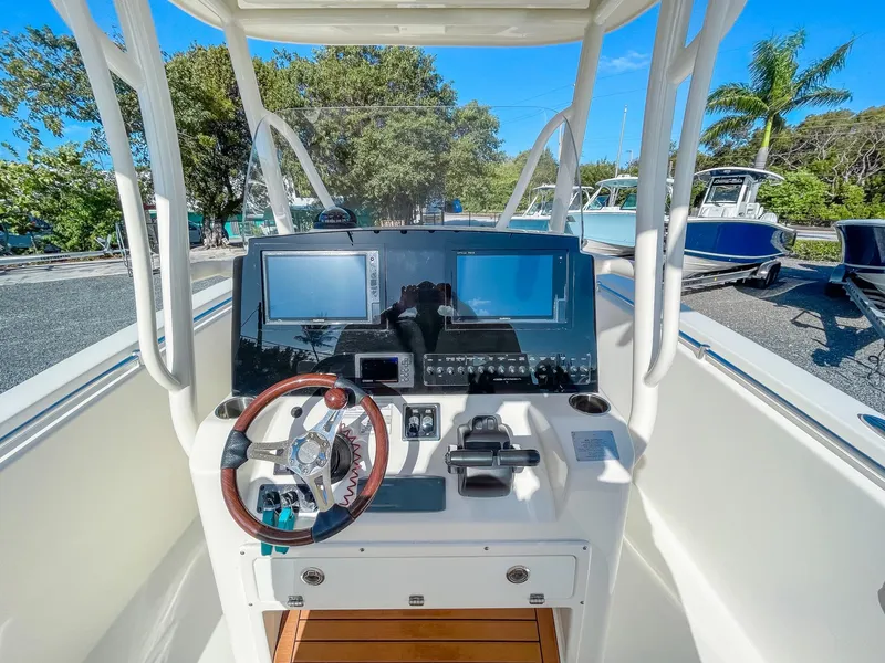 Slide: The Image of 2016 Cobia 277 CC boat dashboard with dual screens and steering wheel. - 14