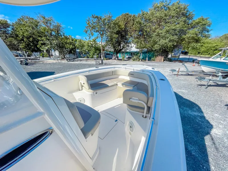 Slide: The Image of 2016 Cobia 277 CC boat interior with seating, parked outdoors. - 17