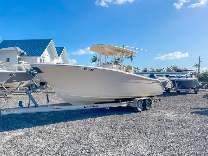 Slide: The Image of 2016 Cobia 277 CC boat on trailer in sunny outdoor setting. - 6