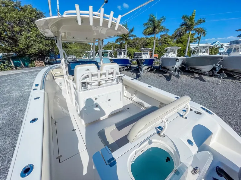 Slide: The Image of 2016 Cobia 277 CC boat with seating and storage, displayed outdoors under blue sky. - 9