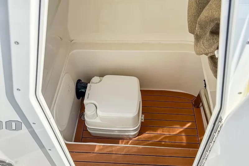 Slide: The Image of 2017 Pathfinder 2600 TRS boat interior with portable toilet on wooden floor. - 20