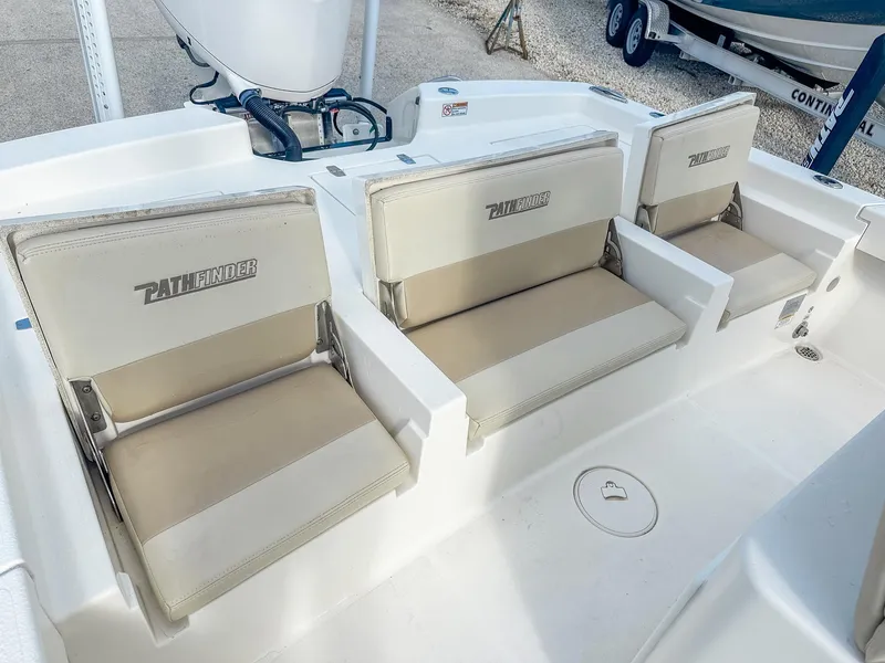 Slide: The Image of 2017 Pathfinder 2600 TRS boat seating area with beige cushions and logo. - 7