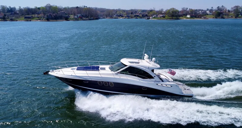 Slide: The Image of 2006 Sea Ray 48 Sundancer yacht cruising on a scenic lake. - 10