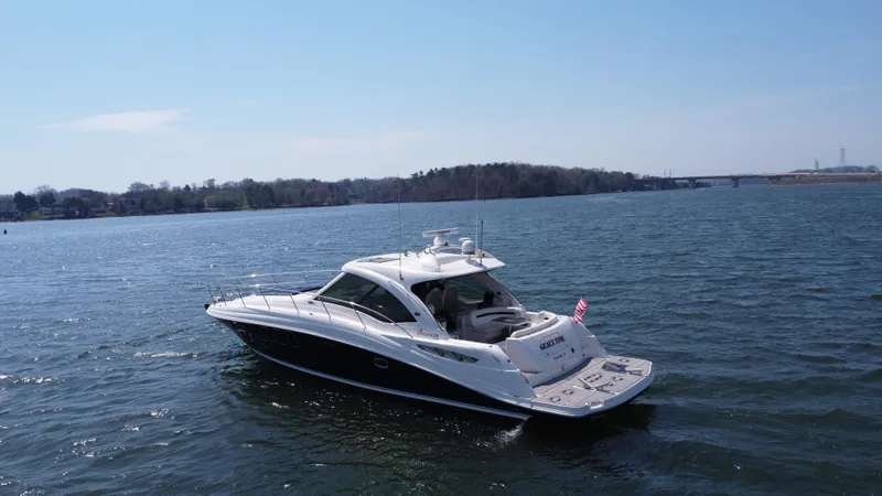 Slide: The Image of 2006 Sea Ray 48 Sundancer yacht cruising on a calm lake. - 17