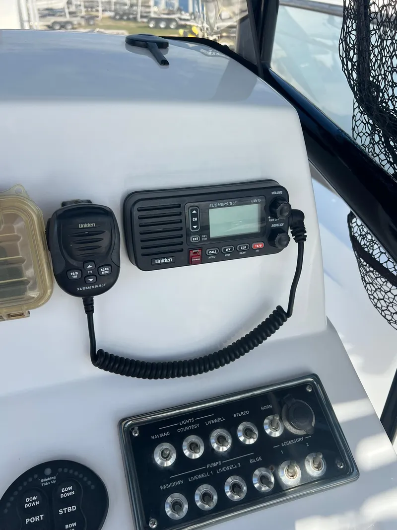 Slide: The Image of Control panel of a 2014 Sportsman Masters 247 Bay Boat with radio and switches. - 12