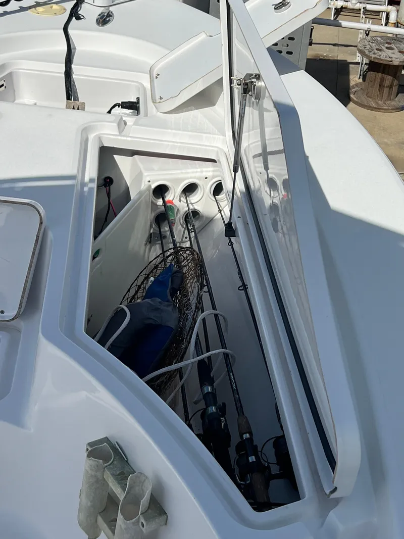 Slide: The Image of 2014 Sportsman Masters 247 Bay Boat storage compartment with fishing gear. - 15