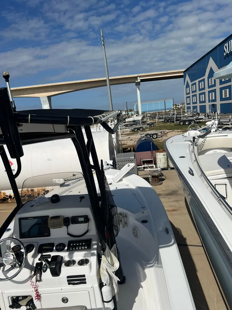 Slide: The Image of 2014 Sportsman Masters 247 Bay Boat docked near a marina under a blue sky. - 30