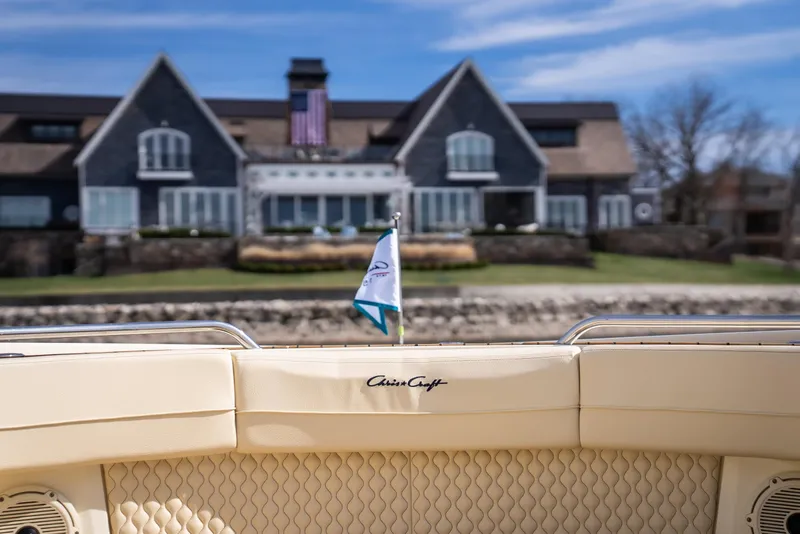 Slide: The Image of 2024 Chris-Craft Calypso 35 CP boat with elegant seating, docked near a luxurious waterfront home. - 10