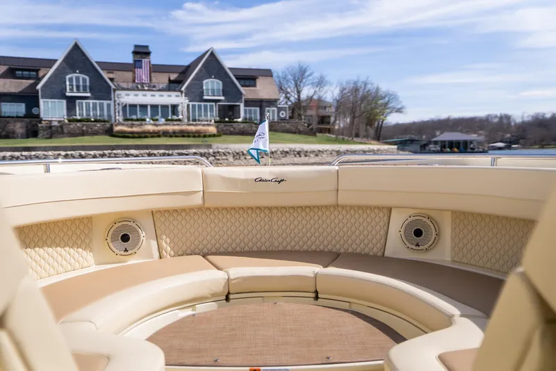 Slide: The Image of 2024 Chris-Craft Calypso 35 CP boat interior with luxury seating, docked near a large house. - 11