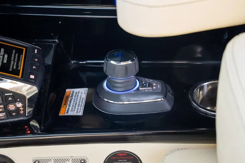 Slide: The Image of 2024 Chris-Craft Calypso 35 CP boat control panel with joystick and cup holder. - 21