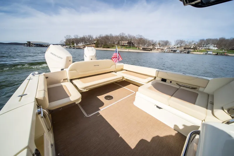Slide: The Image of 2024 Chris-Craft Calypso 35 CP boat with spacious seating, American flag, and scenic lake view. - 30