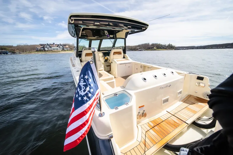 Slide: The Image of 2024 Chris-Craft Calypso 35 CP boat on water, featuring American flag and luxurious deck. - 34