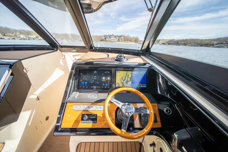Slide: The Image of 2024 Chris-Craft Calypso 35 CP helm with modern navigation system and wooden steering wheel. - 36