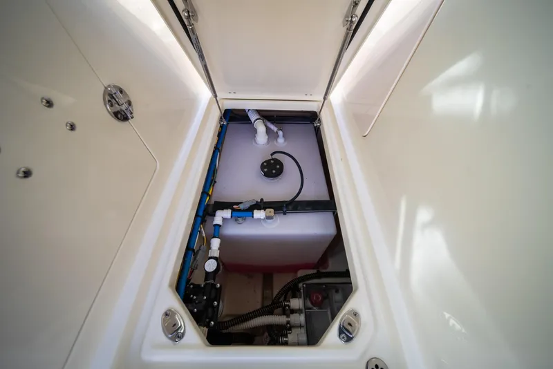 Slide: The Image of 2024 Chris-Craft Calypso 35 CP storage compartment with visible plumbing and wiring. - 39