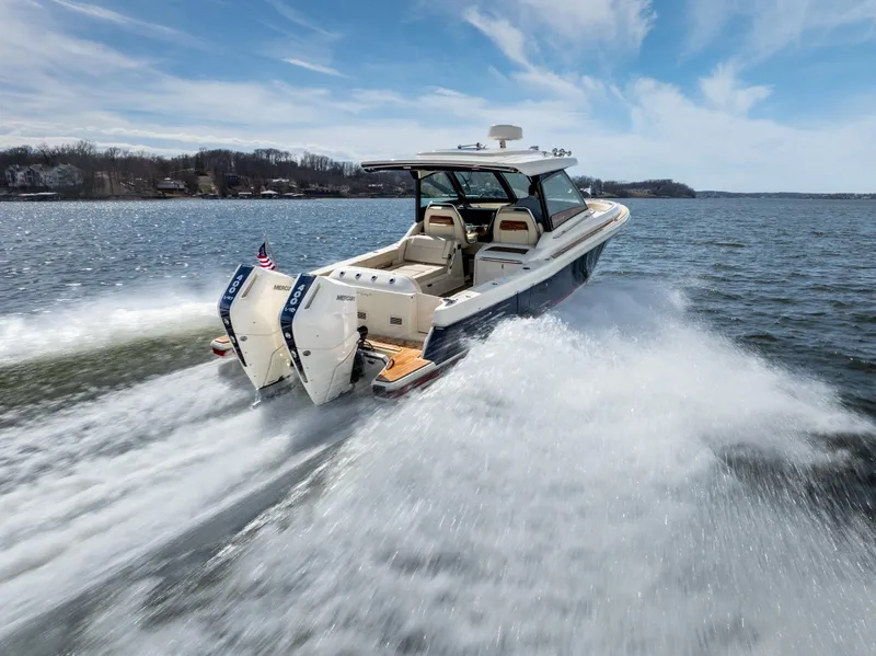 Slide: The Image of 2024 Chris-Craft Calypso 35 CP cruising on a lake under a clear blue sky. - 43