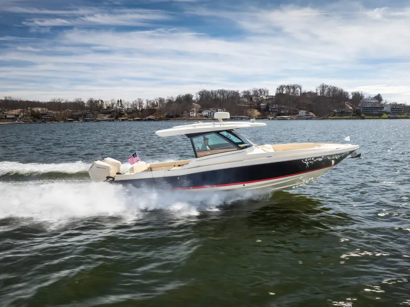 Slide: The Image of 2024 Chris-Craft Calypso 35 CP cruising on a lake under a clear sky. - 44