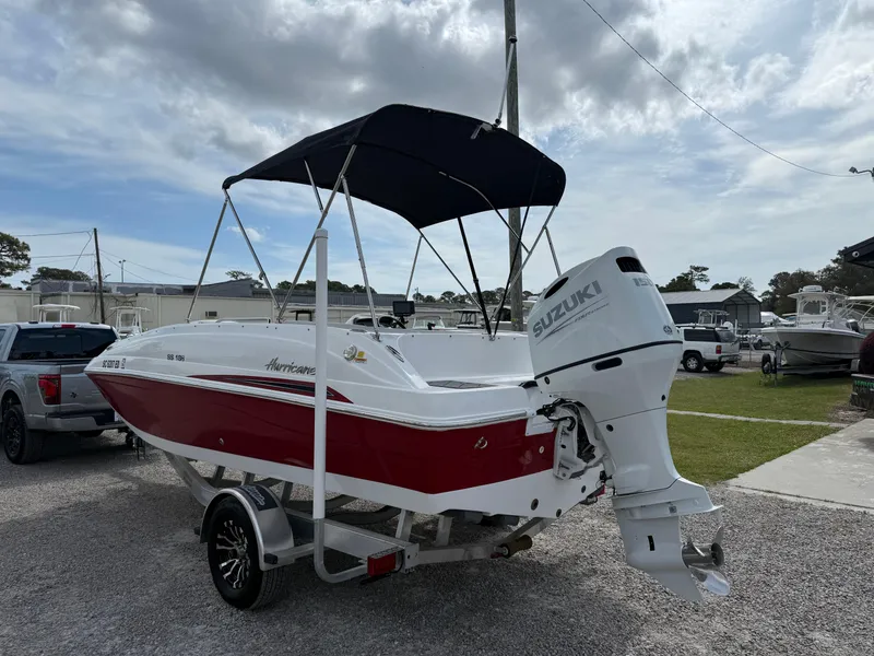 Slide: The Image of 2023 Hurricane SunDeck Sport 188 OB boat with Suzuki outboard motor, parked outdoors. - 3