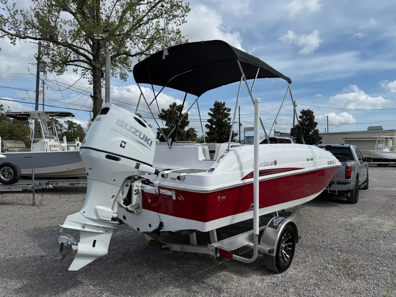 Slide: The Image of 2023 Hurricane SunDeck Sport 188 OB boat with Suzuki outboard motor, parked on a trailer. - 5