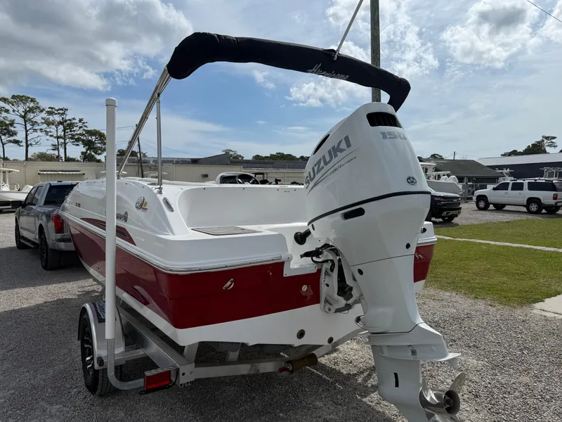 Slide: The Image of 2023 Hurricane SunDeck Sport 188 OB boat with Suzuki outboard motor, parked on a trailer. - 9
