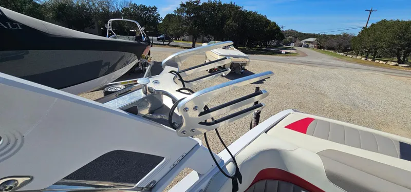 Slide: The Image of 2013 Malibu Wakesetter 23 MXZ boat with wakeboard rack in a sunny outdoor setting. - 23