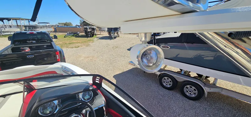 Slide: The Image of 2013 Malibu Wakesetter 23 MXZ boat interior with dashboard and trailer in a parking area. - 25