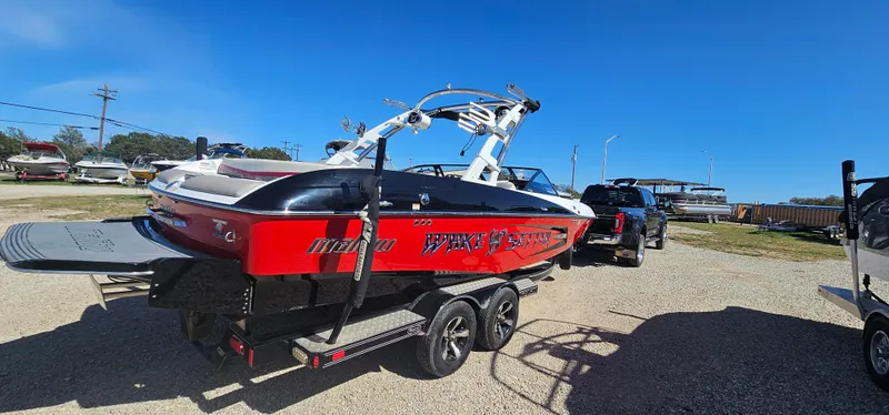 Slide: The Image of 2013 Malibu Wakesetter 23 MXZ boat on trailer, vibrant red and black design. - 3