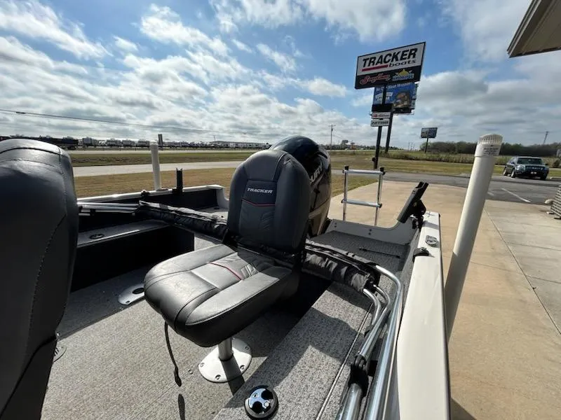 Slide: The Image of 2021 Tracker Pro Guide V 16 boat with seating, displayed outdoors under a cloudy sky. - 10