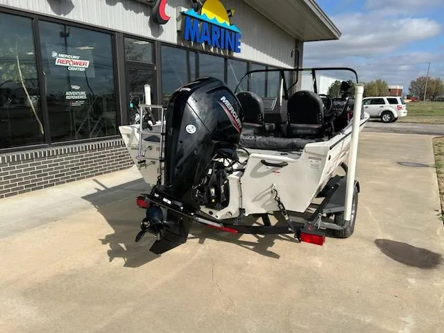 Slide: The Image of 2021 Tracker Pro Guide V 16 boat with Mercury outboard motor, parked outside a marine center. - 3