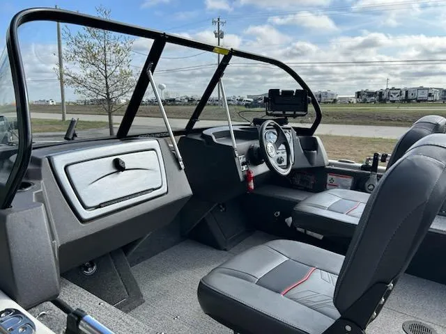 Slide: The Image of 2021 Tracker Pro Guide V 16 boat interior with steering wheel and seating. - 6