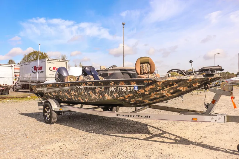 Slide: The Image of 2015 Ranger RT178 boat with camouflage design on a trailer in a parking lot. - 1