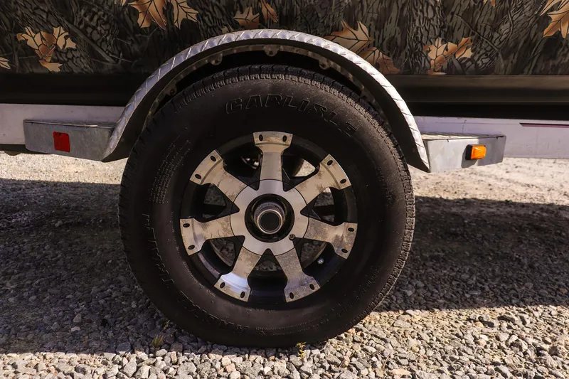 Slide: The Image of 2015 Ranger RT178 trailer wheel with metallic rim on gravel surface. - 10