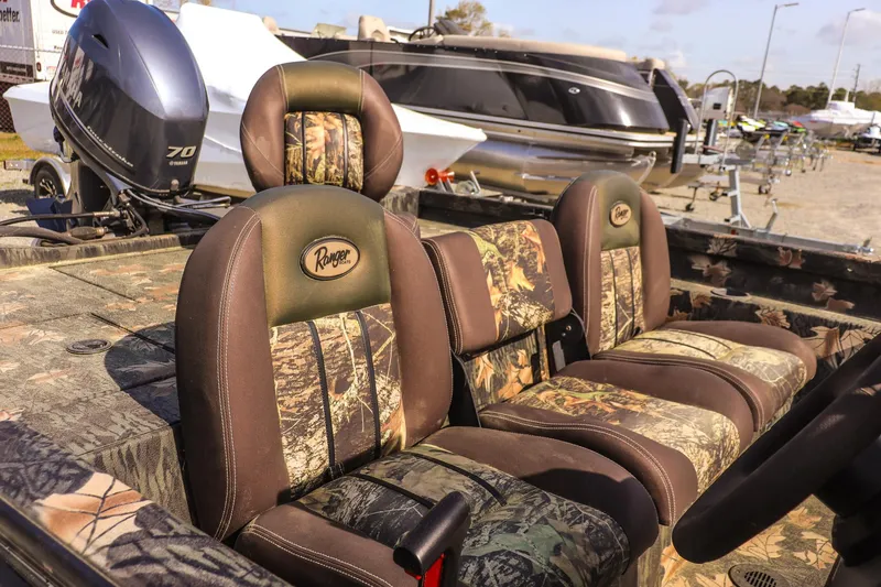 Slide: The Image of 2015 Ranger RT178 boat interior with camo seats, parked near other boats. - 14