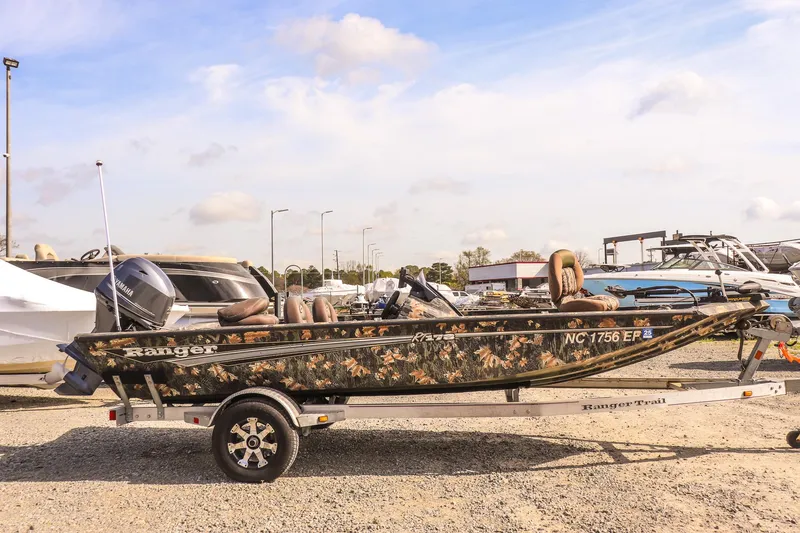 Slide: The Image of 2015 Ranger RT178 boat with camouflage design on a trailer, parked outdoors. - 2