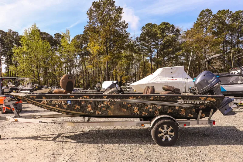 Slide: The Image of 2015 Ranger RT178 boat with camouflage design on a trailer, parked outdoors. - 6