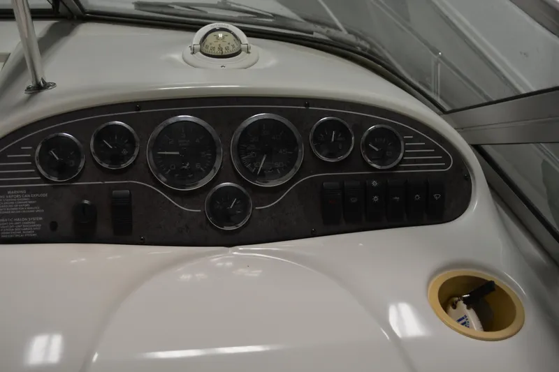 Slide: The Image of 1997 Sea Ray 240 Sundancer dashboard with gauges and controls, featuring a classic design. - 11